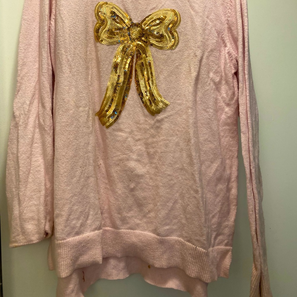 Pink sweater with gold sequin bow.